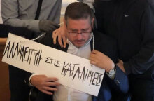 Ο πρύτανης της ΑΣΟΕΕ με την ταμπέλα που του κρέμασαν στον λαιμό οι κουκουλοφόροι