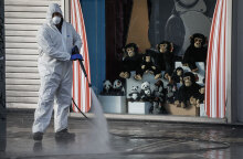 Εργαζόμενος στον Δήμο Αθηναίων με προστατευτική στολή για τον κορωνοϊό προχωρεί σε απολύμανση στο Μοναστηράκι