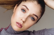 Γυναικείο πρόσωπο με μπλε μάτια και καστανά μαλλιά πιασμένα αλογοουρά