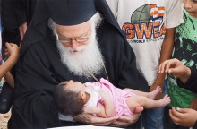 Ο Αρχιεπίσκοπος Αναστάσιος και ένα προσφυγόπουλο από το Κομπάνι