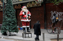 Πολίτες περνούν μπροστά από Άγιο Βασίλη έξω από κλειστά εμπορικά καταστήματα στο κέντρο της Αθήνας εν μέσω lockdown για τον κορωνοϊό