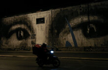 Διανομέας φαγητού περνά με το μηχανάκι μπροστά από τοιχογραφία σε κεντρικό δρόμο της Αθήνας εν μέσω lockdown για τον κορωνοϊό