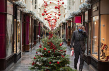 Άνδρας με προστατευτική μάσκα για τον κορωνοϊό περνά δίπλα από χριστουγεννιάτικο δέντρο στο Λονδίνο