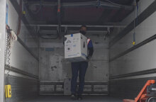 Κορωνοϊός - Κύπρος: Υπάλληλος με προστατευτική μάσκα για τον κορωνοϊό ξεφορτώνει τα πρώτα εμβόλια της Pfizer