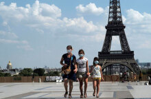 Γαλλία: Τουρίστες με μάσκες για τον κορωνοϊό με φόντο τον Πύργο του Άιφελ στο Παρίσι