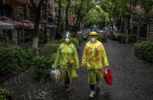 Πολίτες στην Κίνα με προστατευτικές στολές και μάσκες για τον κορωνοϊό