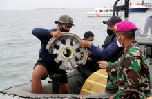 Διασώστες βγάζουν από τη θάλασσα ένα κομμάτι από τη ρόδα του αεροσκάφους της Sriwijaya Air, το οποίο συνετρίβη στην Ινδονησία
