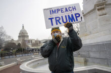 Άνδρας με μάσκα για τον κορωνοϊό ζητά την παραπομπή Τραμπ με φόντο το Καπιτώλιο