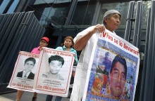 Γονείς κρατούν πανό με τις φωτογραφίες των παιδιών τους που εξαφανίστηκαν 