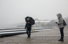 Πολίτες με ζεστά ρούχα και ομπρέλες