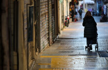 Lockdown στην Αττική: Γυναίκα περνά έξω από κλειστά καταστήματα