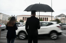 Lockdown στην Αττική: Νεαρός με ομπρέλα στη βροχερή Αθήνα