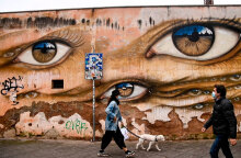 Ιταλία - Κορωνοϊός: Γυναίκα με μάσκα βγάζει βόλτα τον σκύλο στη συνοικία Τραστέβερε στη Ρώμη