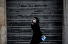 Αττική - Lockdown: Κοπέλα με μάσκα για τον κορωνοϊό μπροστά από κλειστό κατάστημα στην Αθήνα