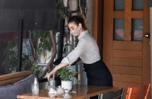 Εργαζόμενη στην εστίαση φορά μάσκα προστασίας