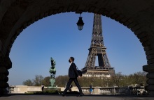 Γαλλία: Πολίτης με μάσκα περπατά με φόντο τον Πύργο του Άιφελ 