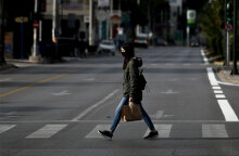 Κορωνοϊός - Ελλάδα: Γυναίκα με μάσκα διασχίζει διάβαση πεζών στην Αθήνα