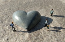 Μινιατούρες ανθρώπων γύρω από γλυπτή καρδιά