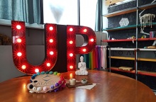 Ξύλινο τραπέζι με αντικείμενα και φωτεινή επιγραφή "UP"