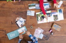 Ξύλινο τραπέζι με τυπωμένες φωτογραφίες και ανθρώπους που πιάνουν πράγματα