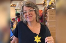 Γυναίκα φορά αυτοκόλλητο κίτρινο αστέρι με την ένδειξη «Δεν είμαι εμβολιασμένος»