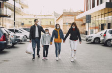 Οικογένεια πιασμένη από το χέρι περπατάει στο δρόμο