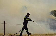 Πυροσβέστης ρίχνει νερό σε εστία πυρκαγιάς (ΦΩΤΟ ΑΡΧΕΙΟΥ) - Στα Καλύβια Αττικής εκδηλώθηκε φωτιά, προκαλώντας συναγερμό στην Πυροσβεστική Υπηρεσία