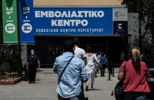Πολίτες με μάσκα έξω από εμβολιαστικό κέντρο