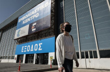 Κοπέλα με μάσκα για τον κορωνοϊό έξω από το mega εμβολιαστικό κέντρο στο Ελληνικό