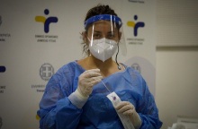 Γυναίκα διενεργεί rapid test φορώντας μάσκα και γάντια