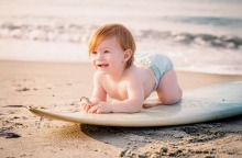 Μωρό σε σανίδα του σερφ στην παραλία