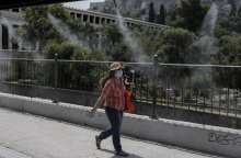 Κύμα καύσωνα - Γυναίκα με γυαλιά ηλίου και καπέλο στην Αθήνα