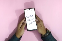 Smartphone στο οποίο αναγράφεται η φράση Work From Home