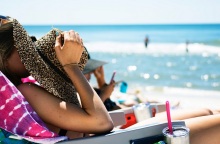 Μια κοπέλα απολαμβάνει τον ήλιο στην παραλία.