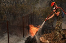 Πυροσβέστης ρίχνει νερό σε φωτιά (ΦΩΤΟ ΑΡΧΕΙΟΥ)