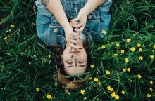 Μια γυναίκα ποζάρει ανάμεσα στα λουλούδια.