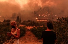 Δύο κάτοικοι παρακολουθούν τις φλόγες να φτάνουν στο χωριό Γούβες. 