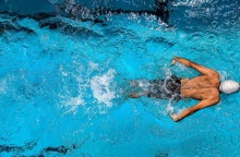 Ένας άντρας κολυμπάει σε μια πισίνα.