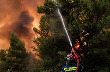 Πυροσβέστης ρίχνει νερό σε δασική πυρκαγιά