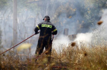 Πυροσβέστης ρίχνει νερό σε φωτιά (ΦΩΤΟ ΑΡΧΕΙΟΥ) - Συναγερμός σε Αττική και Εύβοια καθώς είναι ακραίος ο κίνδυνος πυρκαγιάς την Κυριακή 22 Αυγούστου 2021