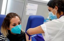 Γυναίκα με μάσκα για τον κορωνοϊό κάνει το εμβόλιο για την Covid-19 