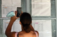 Γυναίκα φωτογραφίζει με το κινητό της τηλέφωνο τις βαθμολογίες των υποψηφίων των πανελλαδικών εξετάσεων 
