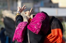 Γυναίκα με μαντήλα βγάζει σέλφι φωτογραφία σχηματίζοντας το σήμα της νίκης