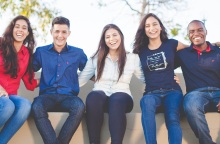 Νέα παιδιά καθισμένα αγκαλιάζονται