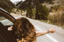Μια κοπέλα βγάζει το χέρι από το παράθυρο κατά τη διάρκεια ενός roadtrip. 