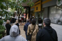 Πολίτες περιμένουν στην ουρά για να μπουν στην τράπεζα