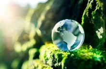 Σταγόνα που μοιάζει με τον πλανήτη γη, ακουμπισμένη σε πόα