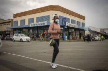 Γυναίκα με μάσκα περπατά σε δρόμο, στη Νότιο Αφρική