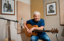 Ο Γιώργος Δημητριάδης κρατά ακουστική κιθάρα στο στούντιο