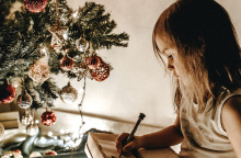 Μικρό κοριτσάκι δίπλα στο χριστουγεννιάτικο δέντρο